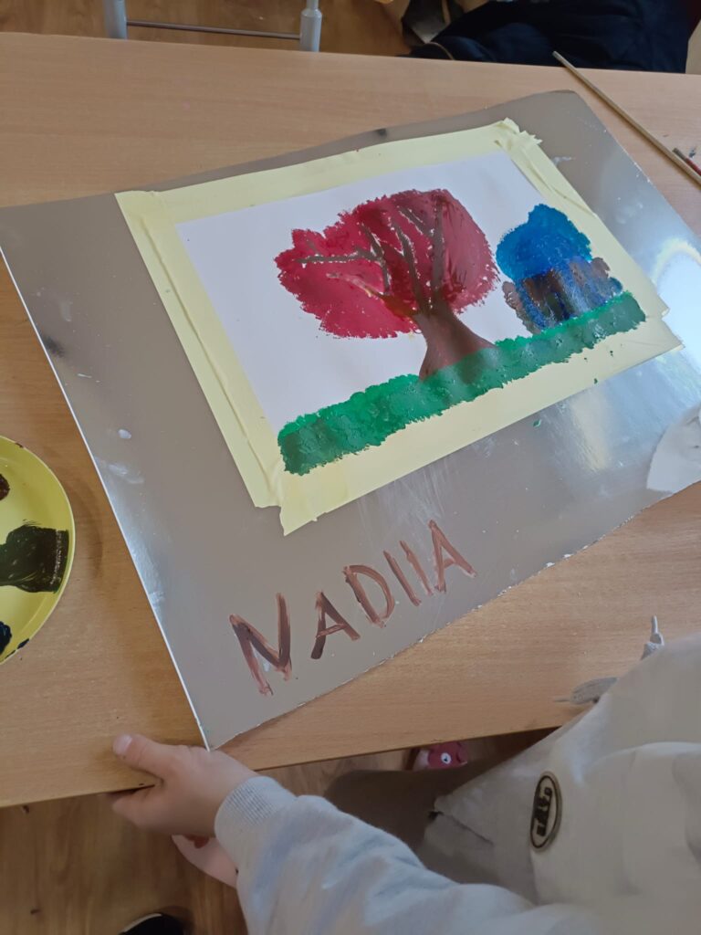 Zdjęcie przedstawia dokumentację warsztatów plastycznych. Dzieci malują akwarelami.